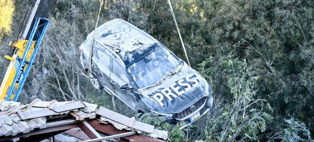 Photos from the scene of the attack showed overturned and damaged cars, some marked “Press”.